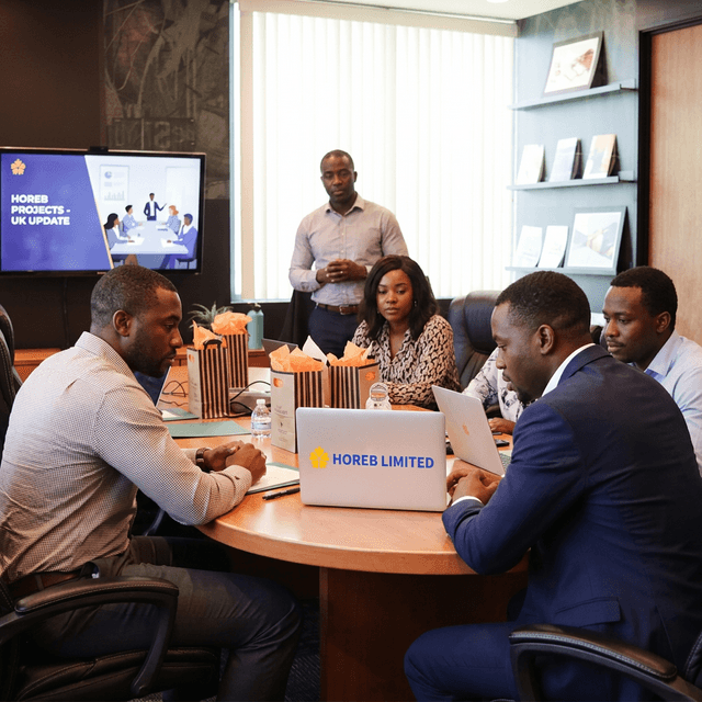 The Horeb Limited team meeting around a laptop in an office